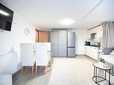 a kitchen and living room with a table and chairs at Grand Family Residence Ljubljana in Ljubljana
