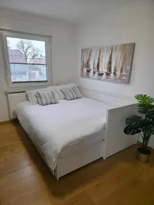 a white bed in a room with a window at Grand Family Residence Ljubljana in Ljubljana