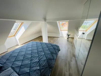 a attic bedroom with a bed and windows at Vacation Station Ptuj in Videm pri Ptuju