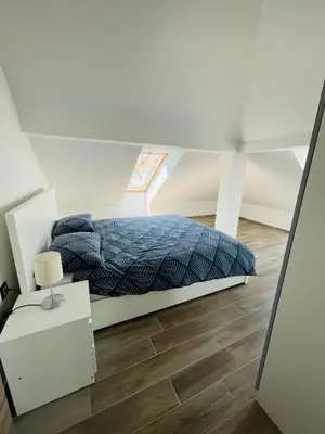 a white bedroom with a bed in a attic at Vacation Station Ptuj in Videm pri Ptuju