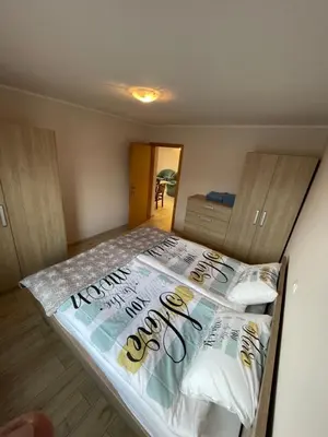 a bedroom with a bed with a sign on it at Apartma Ivana in Markovci