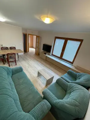 a living room with two blue couches and a table at Apartma Ivana in Markovci