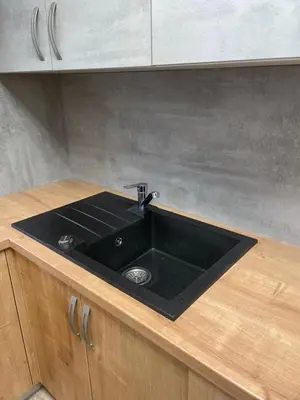 a kitchen sink with a black counter top at Apartma Ivana in Markovci