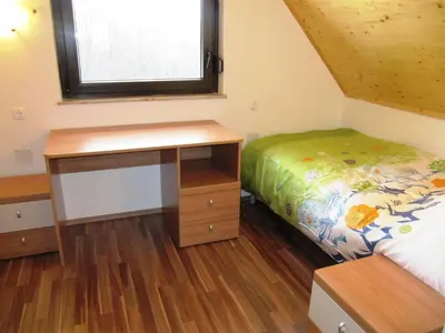 a small bedroom with a bed and a desk at Holiday Home Češnovar in Raka