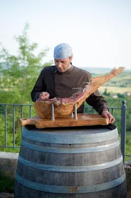 a man standing on top of a barrel at Klinec Plešivo Art Rooms in Dobrovo
