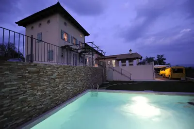 a swimming pool in front of a house at Klinec Plešivo Art Rooms in Dobrovo