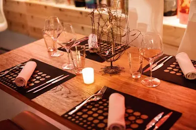 a wooden table with wine glasses and napkins on it at Klinec Plešivo Art Rooms in Dobrovo