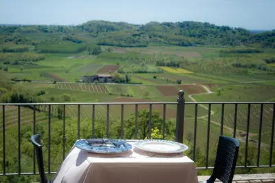 a table and chairs with a view of a valley at Klinec Plešivo Art Rooms in Dobrovo