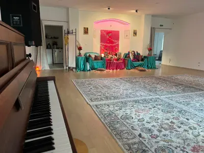 a living room with a piano and a table with chairs at OM Yoga center in Slovenska Bistrica