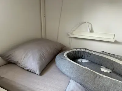a bed in a room with a pillow and a shelf at OM Yoga center in Slovenska Bistrica