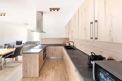 a kitchen with wooden cabinets and a table and chairs at Duplex Holiday Apartment in Škofljica