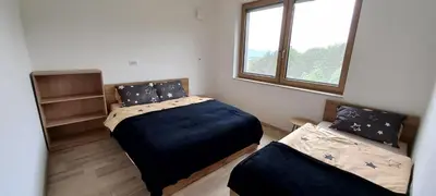 a bedroom with two beds and a window at Duplex Holiday Apartment in Škofljica