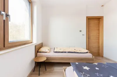 a small bedroom with a bed and a window at Duplex Holiday Apartment in Škofljica