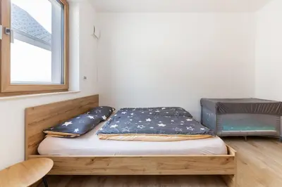 a bed sitting in a room with a window at Duplex Holiday Apartment in Škofljica