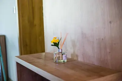 a vase with a yellow flower on a wooden table at APARTMAJI SILVA in Slappe dʼIdria