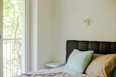 a bed with a black headboard and pillows next to a window at APARTMAJI SILVA in Slappe dʼIdria