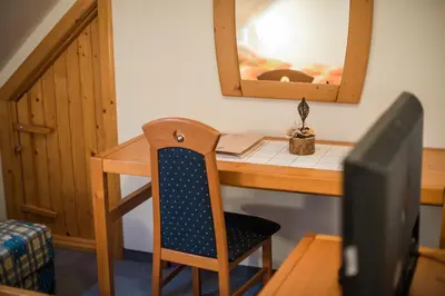 a wooden desk with a chair and a mirror at Bed & Breakfast Hisa Resje in Bohinj