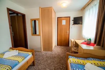 a small room with two beds and a desk at Bed & Breakfast Hisa Resje in Bohinj