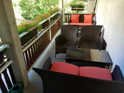 a balcony with chairs and a table and a couch at Guesthouse Pri Štefanu in Most na Soči