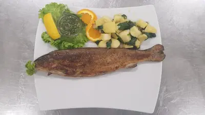 a plate of food with a fish and vegetables at Guesthouse Pri Štefanu in Most na Soči