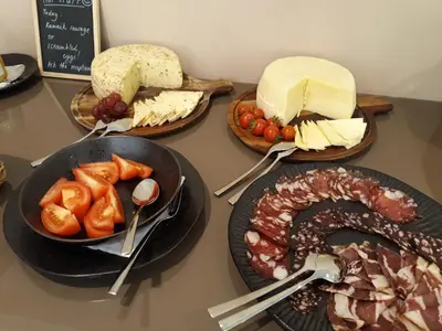 a table topped with different types of cheese and meats at Penzion Repnik in Kamnik