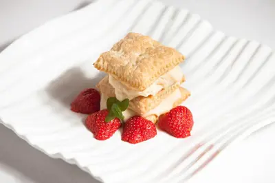a sandwich and two strawberries on a white plate at Penzion Repnik in Kamnik