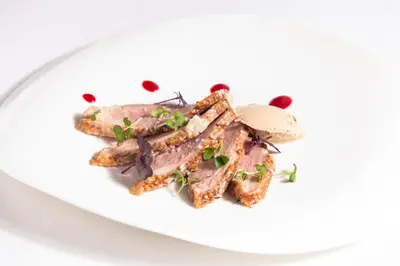 a plate of food with meat on a white plate at Penzion Repnik in Kamnik