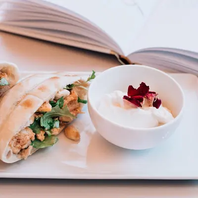 a plate with a sandwich and a bowl of dip at Apartment Vila Pavlovski in Bled
