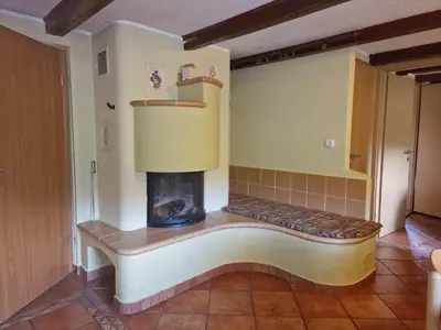 a living room with a fireplace in the corner at Apartments Relax Jezerca in Cerklje na Gorenjskem
