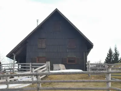 a black barn with a fence in front of it at Apartments Relax Jezerca in Cerklje na Gorenjskem