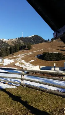 a fence in a field with a mountain in the background at Apartments Relax Jezerca in Cerklje na Gorenjskem