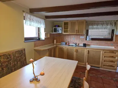 a kitchen with a wooden table and a table and a table at Apartments Relax Jezerca in Cerklje na Gorenjskem