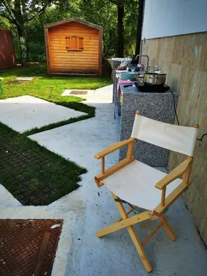 a wooden chair sitting in front of a grill at Krasen Kras 104 resort in Komen