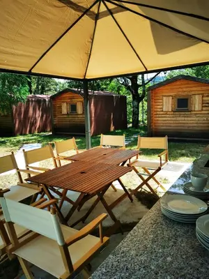 a wooden table and chairs under an umbrella at Krasen Kras 104 resort in Komen