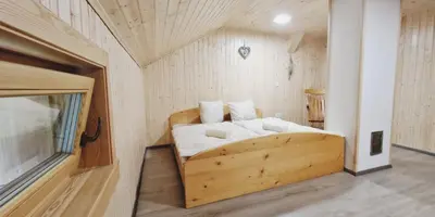 a bedroom with a wooden bed in a room at Mountain hut Dom pod Storžičem in Tržič
