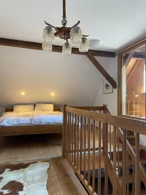 a bedroom with a bed and a staircase at Pr Krač Countryside Hideaway in Dol pri Ljubljani