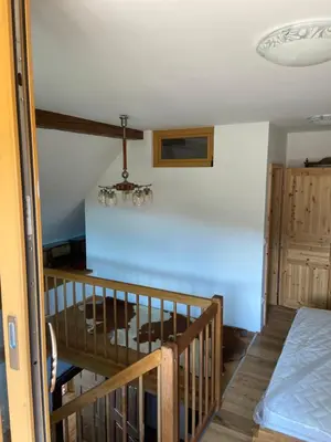 a room with a bed and a table with a chandelier at Pr Krač Countryside Hideaway in Dol pri Ljubljani