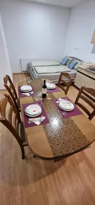 a dining room table with chairs and a purple table cloth at APARTMAN MURKO P-4 in Ljubljana
