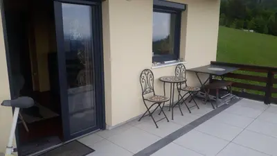 a balcony with three chairs and a table on a porch at Kralj Matjaž - the green escape under Alps in Golnik