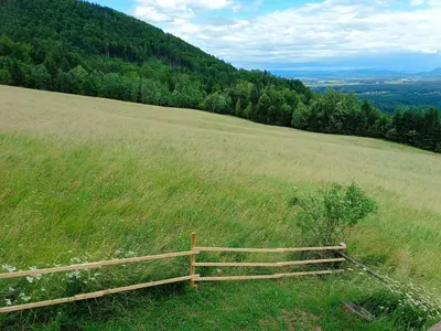 a wooden fence on top of a field of grass at Kralj Matjaž - the green escape under Alps in Golnik