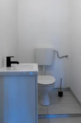 a white bathroom with a toilet and a sink at Apartment Bogomila in Ljubljana