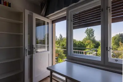 a room with windows and a table with a view at Apartment Bogomila in Ljubljana