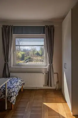 a bedroom with a window and a bed and a wooden floor at Apartment Bogomila in Ljubljana