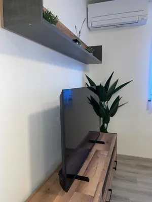 a mirror on a wooden table with a potted plant at APARTMA DŽANA in Žaga