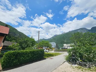 a bike parked on the side of a street with mountains at APARTMA DŽANA in Žaga