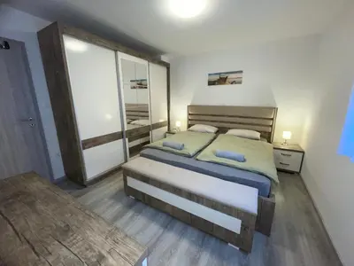 a bedroom with a large bed and a mirror at APARTMA DŽANA in Žaga