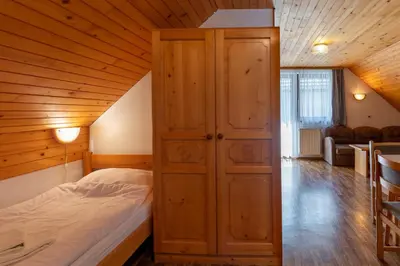 a bedroom with a bed in a wooden room at Apartment Malej in Bohinj