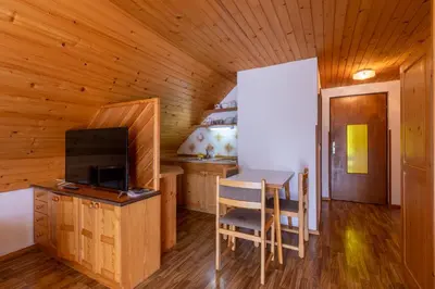 a dining room with a table and a television in a cabin at Apartment Malej in Bohinj