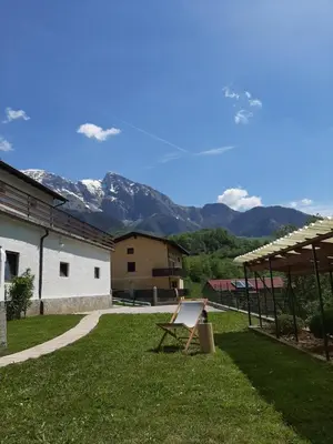 a chair in a yard with mountains in the background at Holiday House Dori in Kobarid