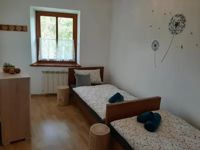 a bedroom with two twin beds and a window at Holiday House Dori in Kobarid
